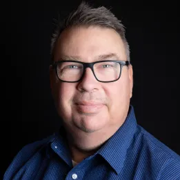 Caucasian man with brown hair wearing glasses