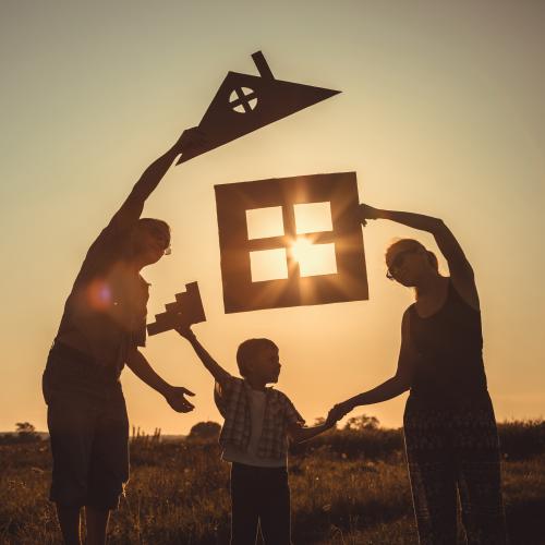 Family holding house stencils against the sun